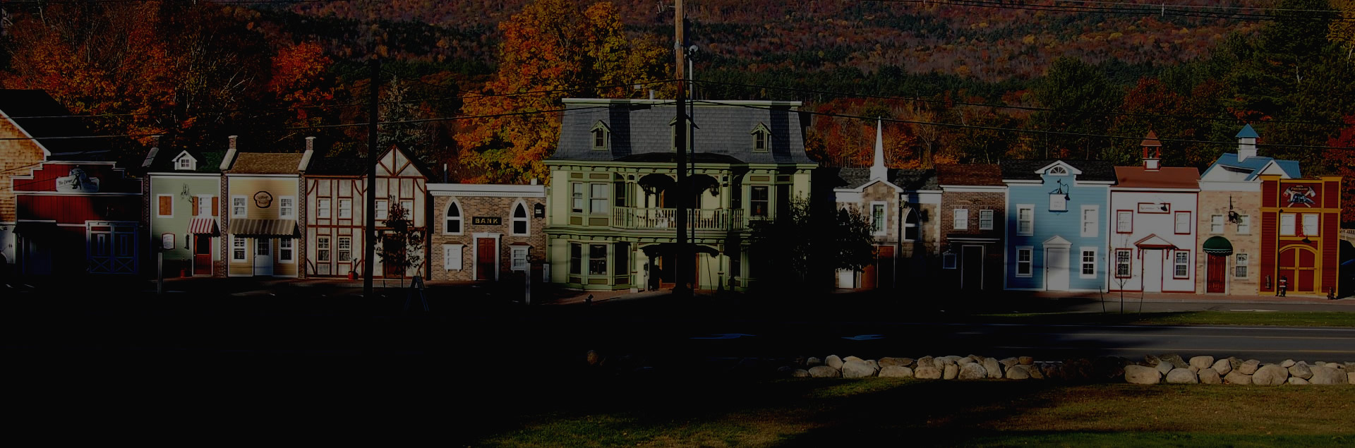 A miniature model of a colorful town with buildings and trees in the background.